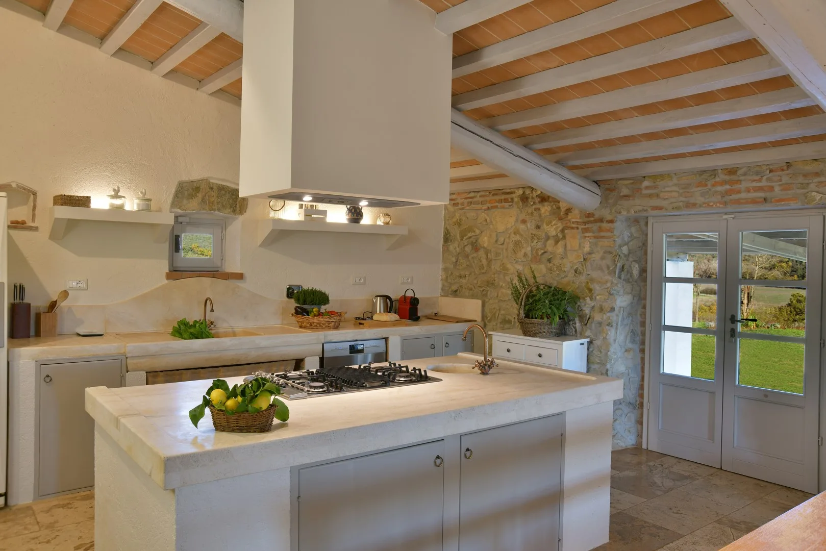 Una cocina luminosa con una gran isla central y vigas de madera vistas en el techo.