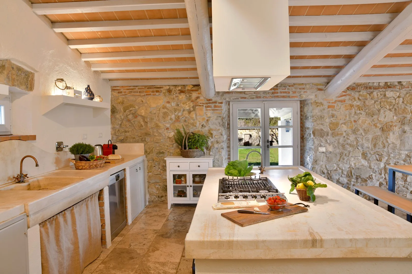 Una cocina rústica con paredes de piedra y una gran isla central.