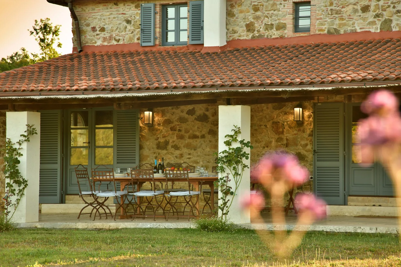 Una casa de piedra con un patio cubierto y una mesa de comedor exterior.