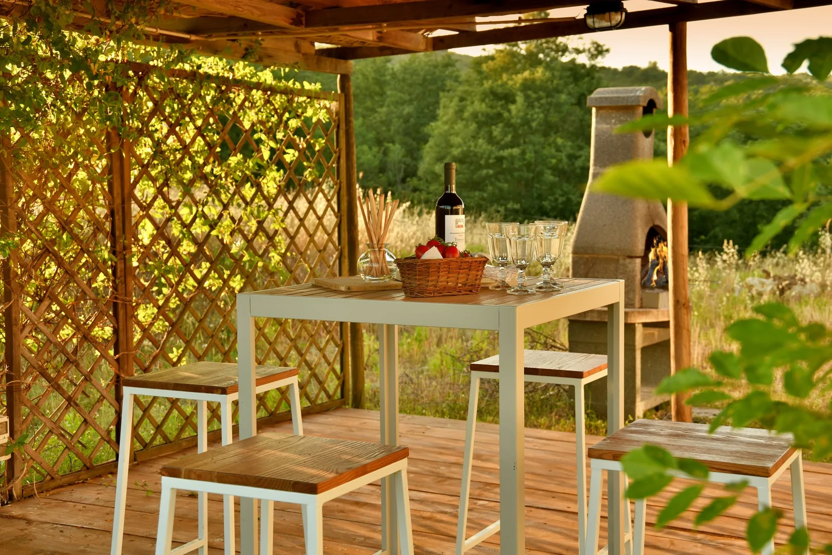 Una zona exterior cubierta para comer, con mesa, asientos y una parrilla.