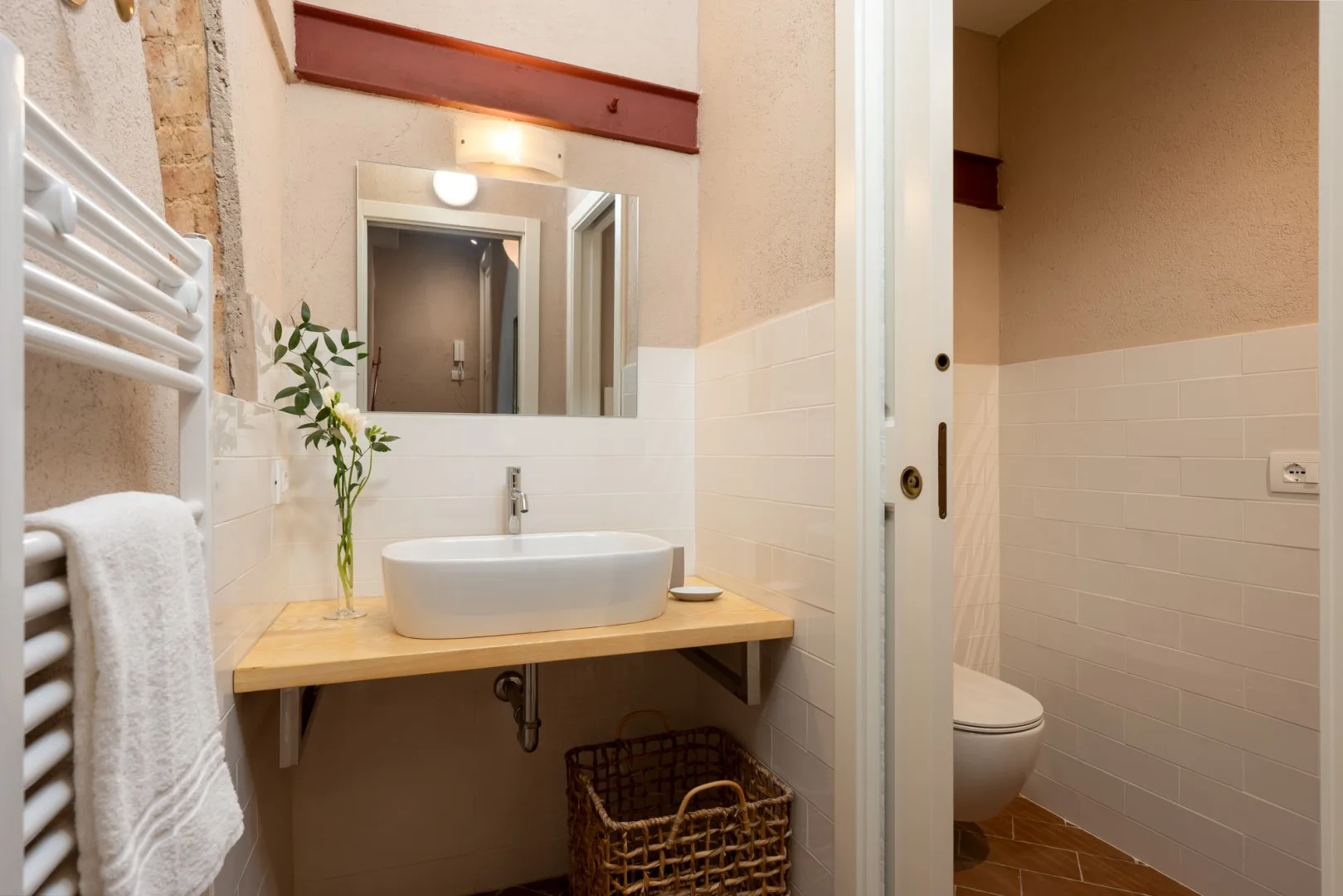 Un lavabo de baño con espejo y toallero calefactable.