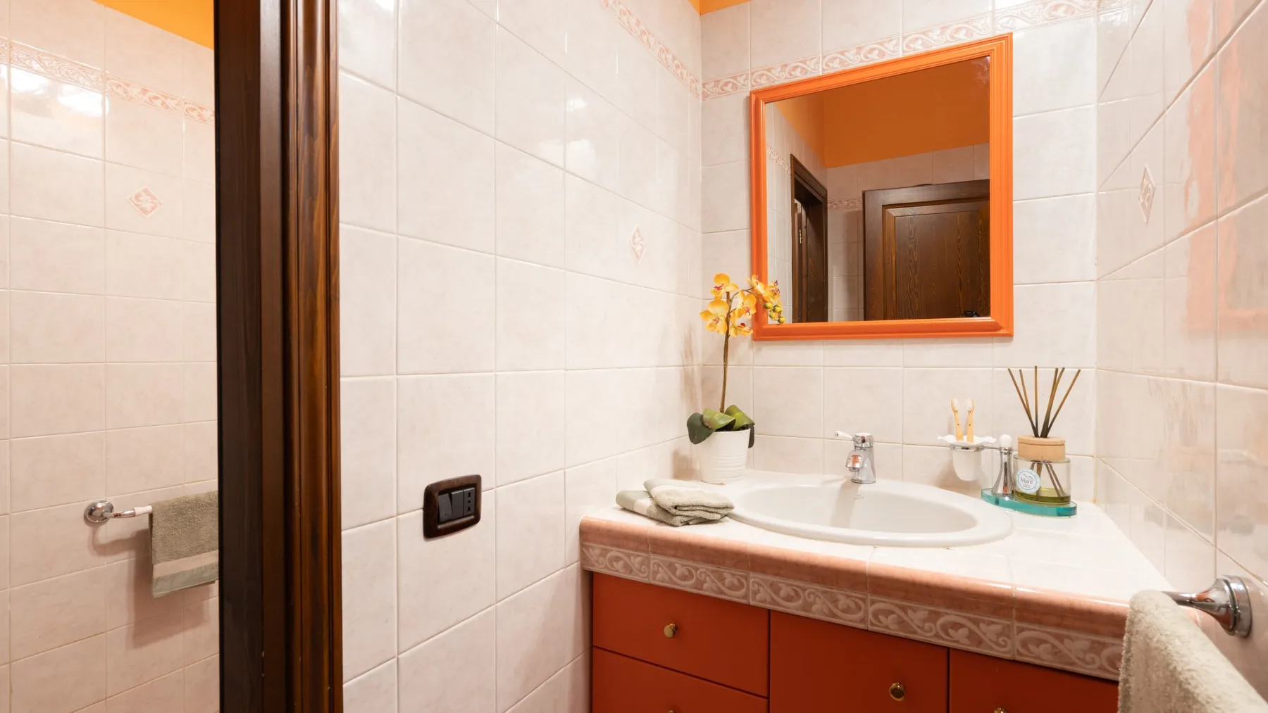 Un baño alicatado con lavabo y espejo.