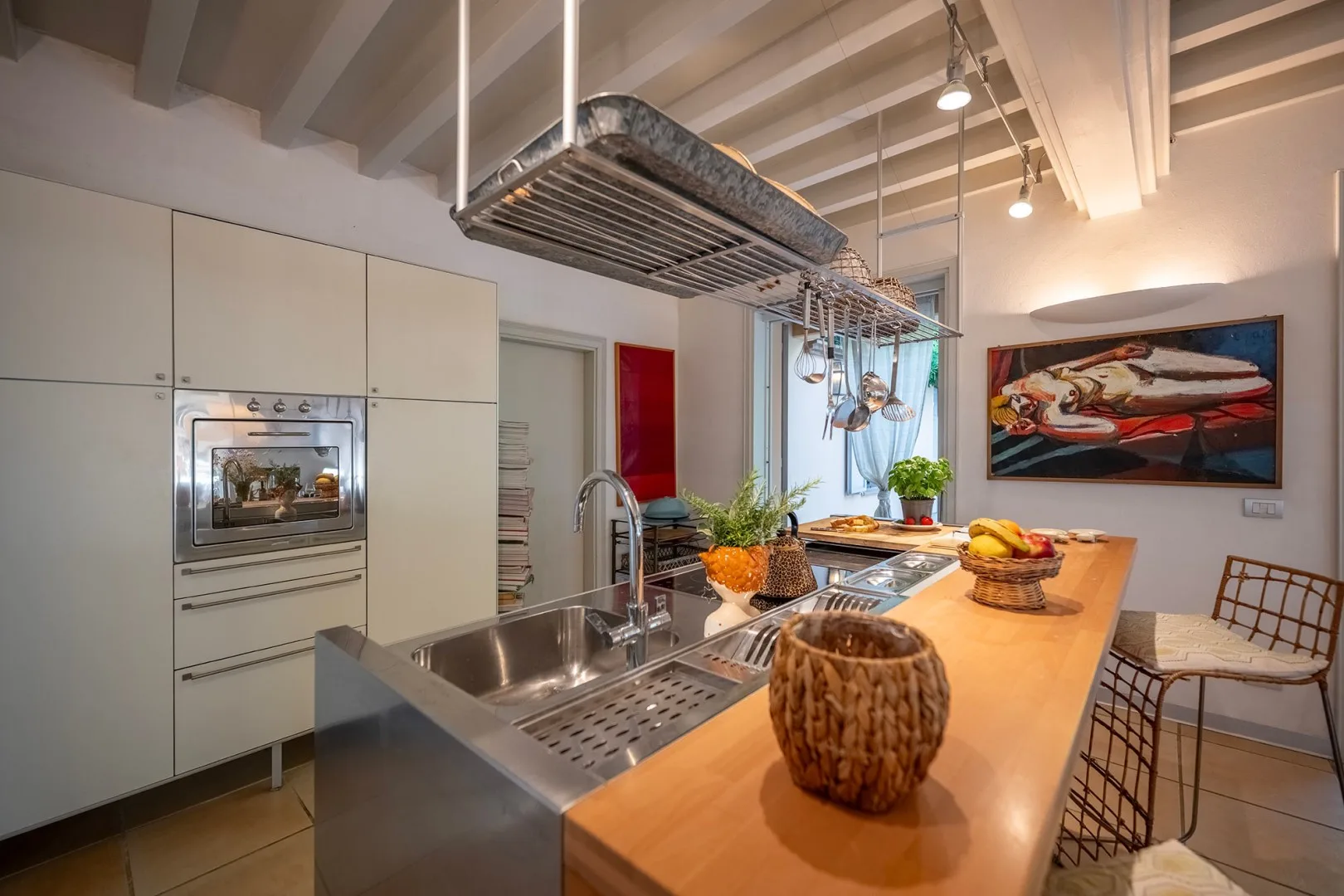 Una cocina moderna con fregadero de acero inoxidable y una larga isla de madera.