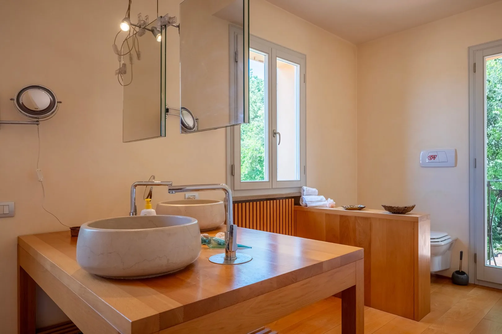 Un lavabo de baño con un fregadero redondo está junto a una ventana.