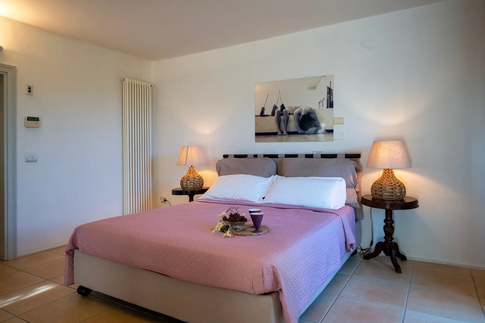 Un dormitorio con una cama doble, mesitas de noche y lámparas a juego.