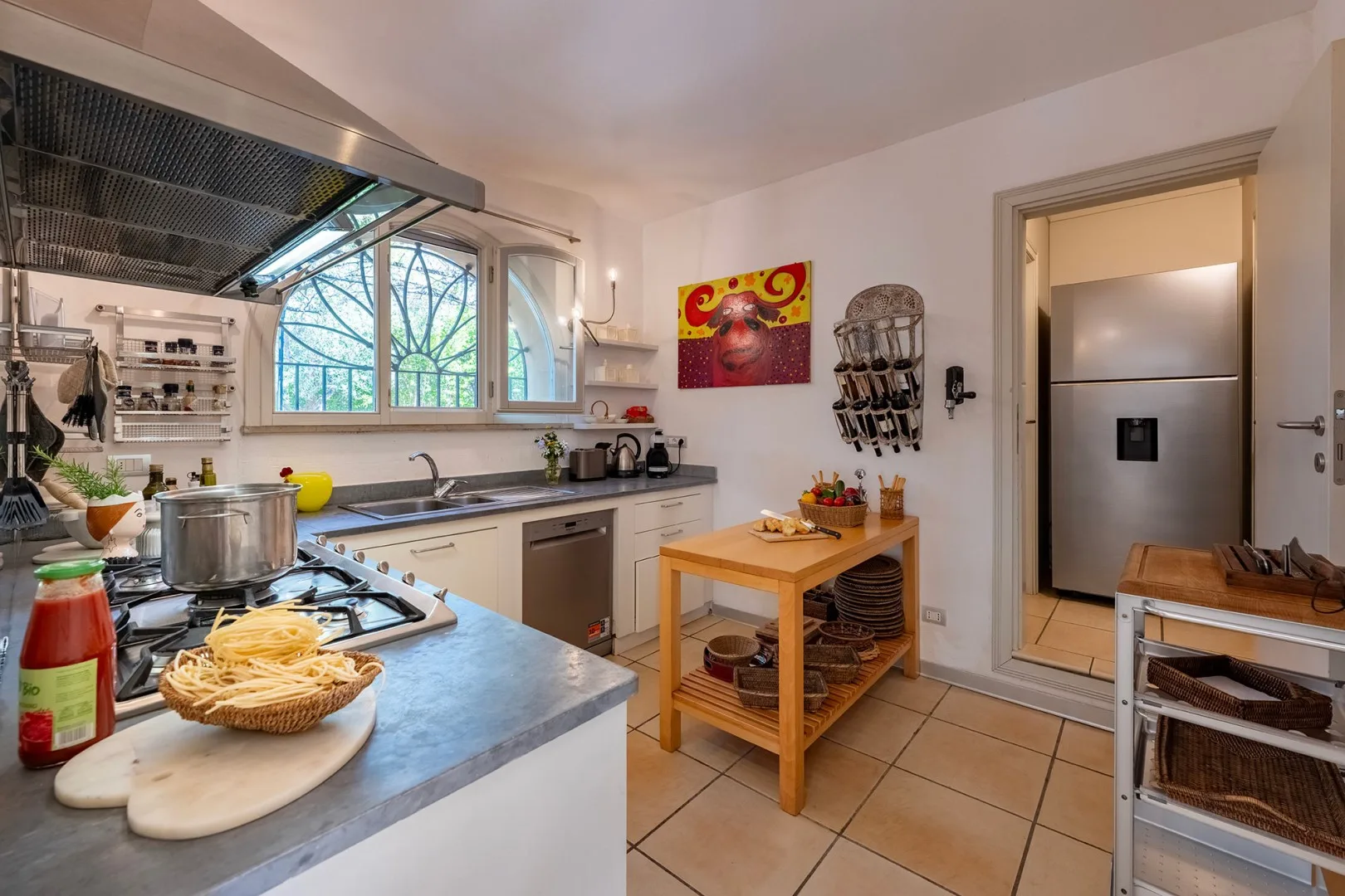 Una cocina luminosa con una mesa de trabajo de madera y una ventana grande.