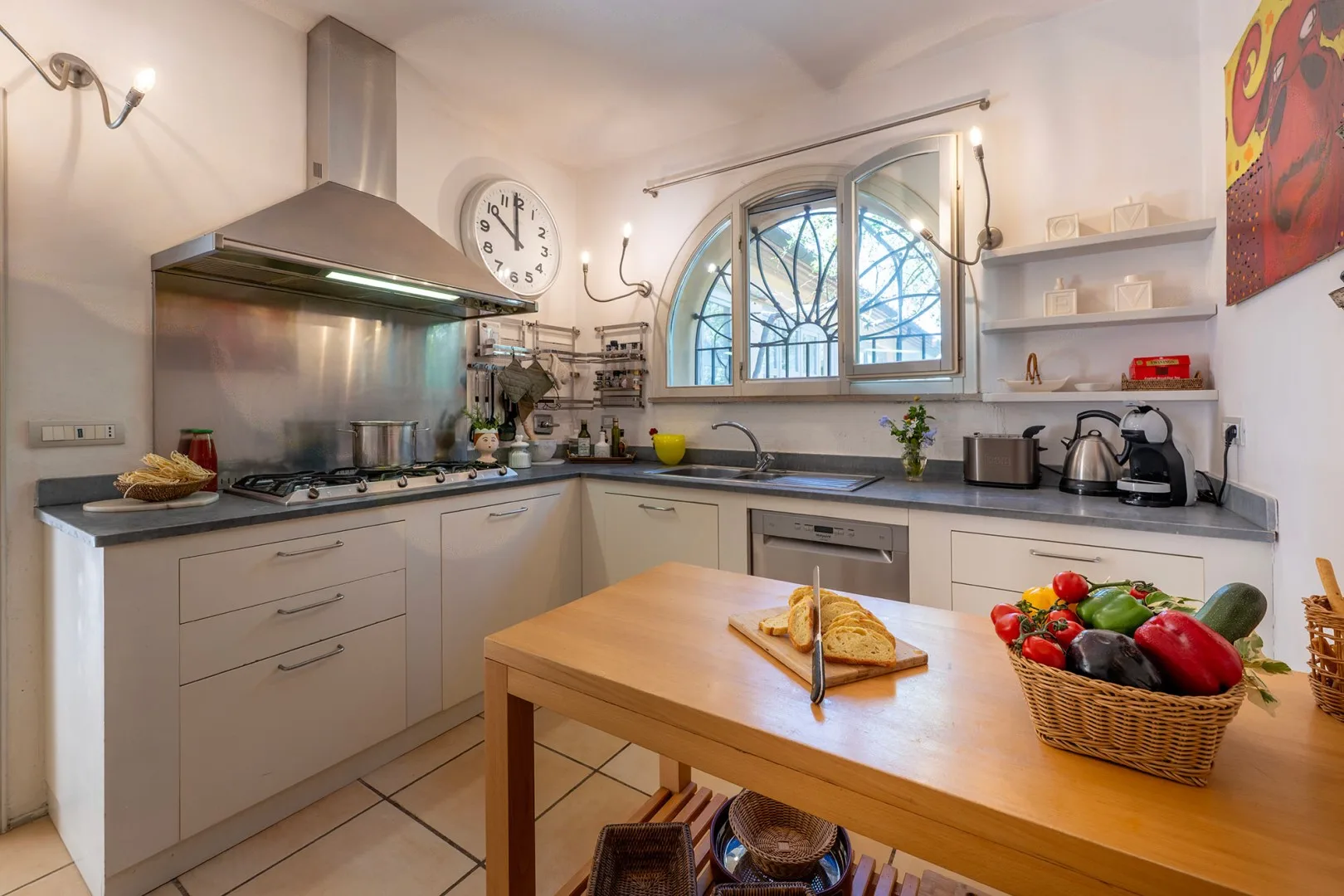 Una cocina luminosa con una mesa de madera y una ventana arqueada.