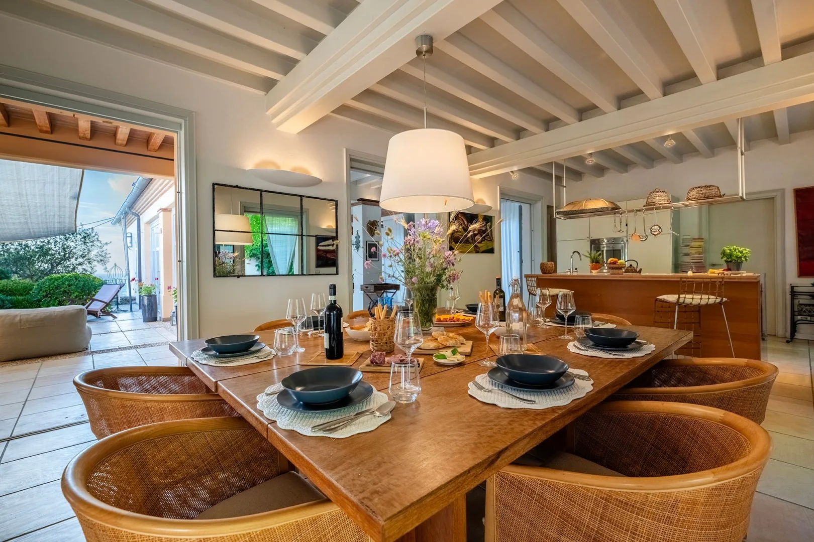 Comedor con una mesa de madera preparada para comer junto a una cocina abierta.