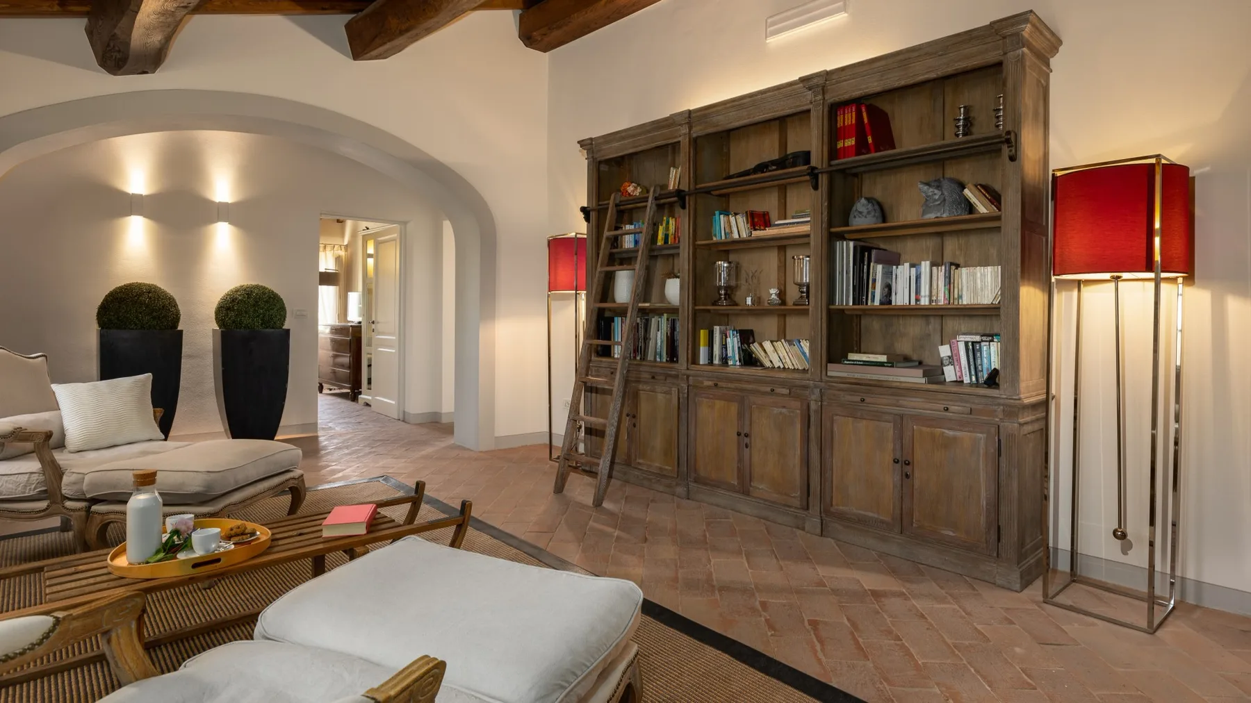 Una sala de estar con una gran estantería de madera y asientos.