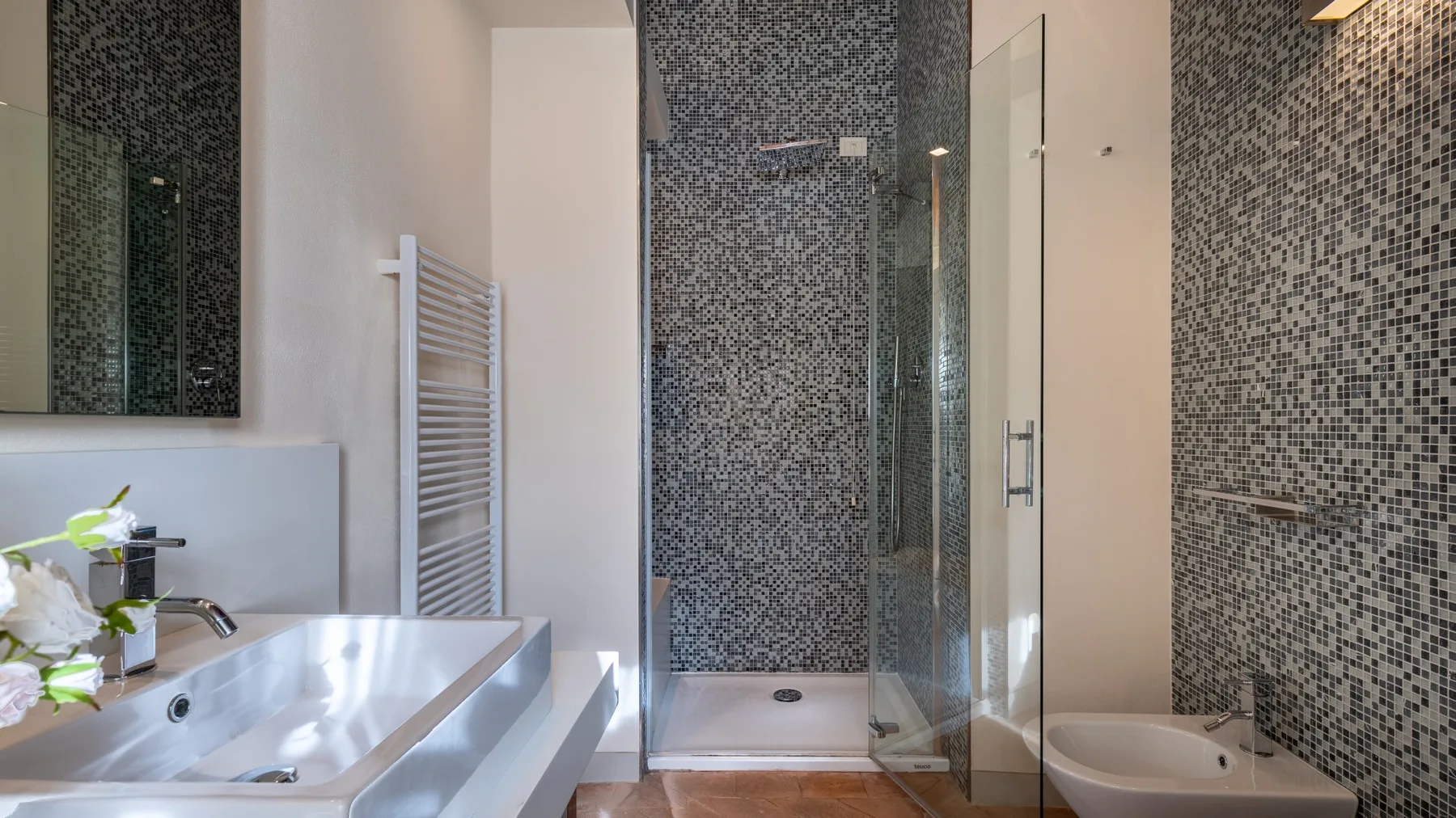 Un baño moderno con lavabo, bañera y ducha de vidrio.