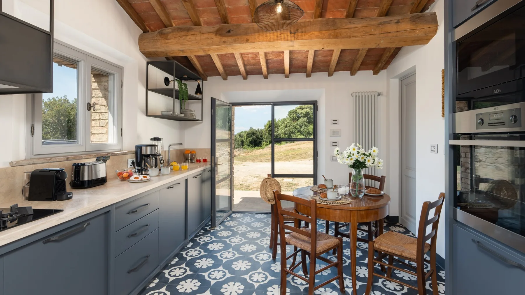 A kitchen and dining area with blue cabinets and a wooden table.