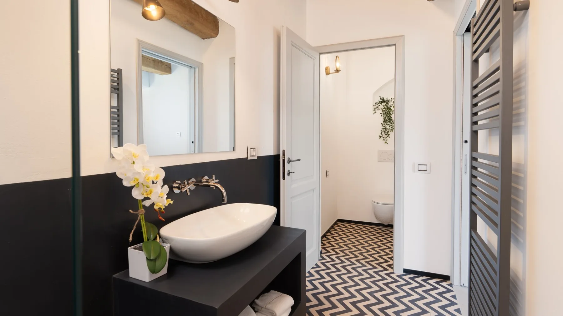 A bathroom vanity with a vessel sink and an open doorway to a tiled room.