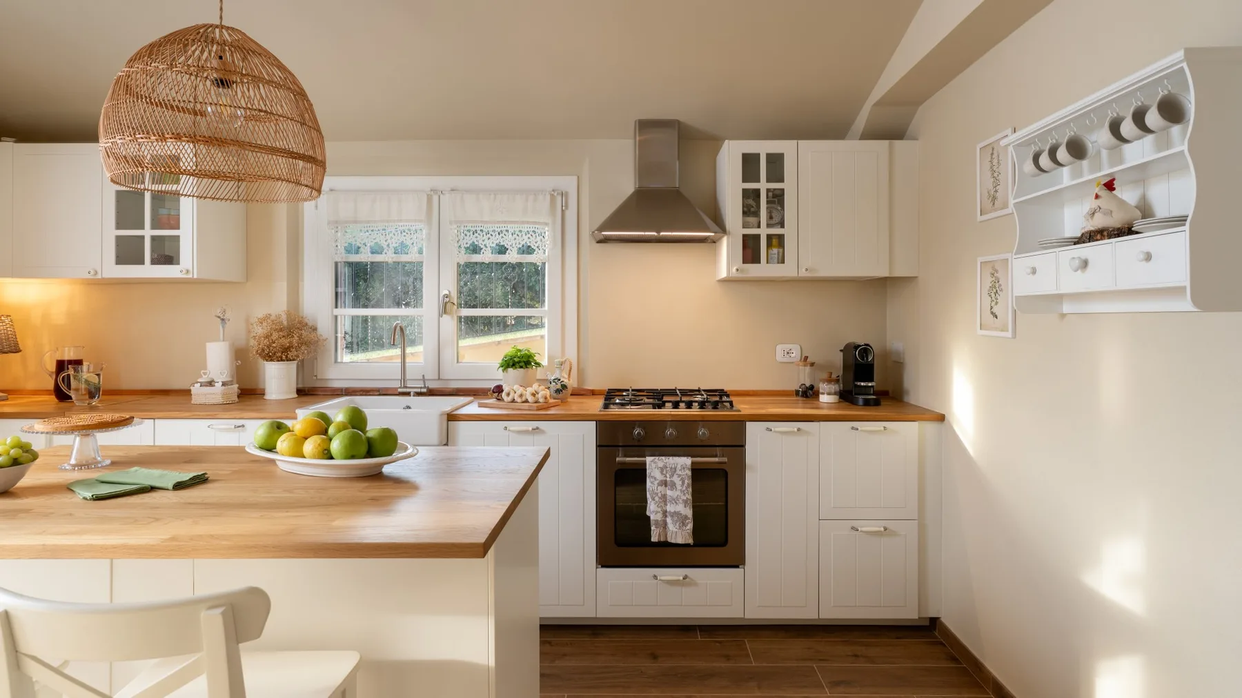 Una cocina luminosa con gabinetes blancos, una isla de madera y una ventana sobre la encimera.