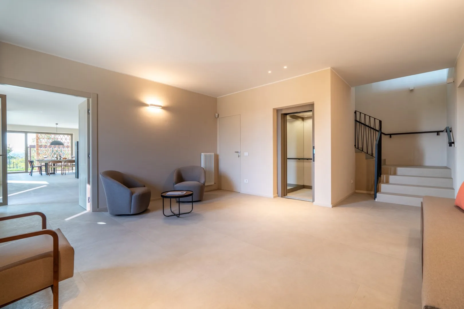 A spacious interior opens onto a sitting area and a staircase.