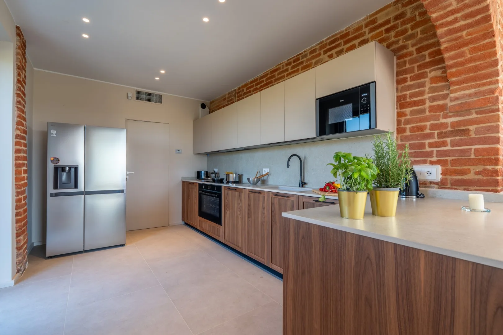 A modern kitchen with wood cabinets, stainless steel appliances, and a broad countertop.