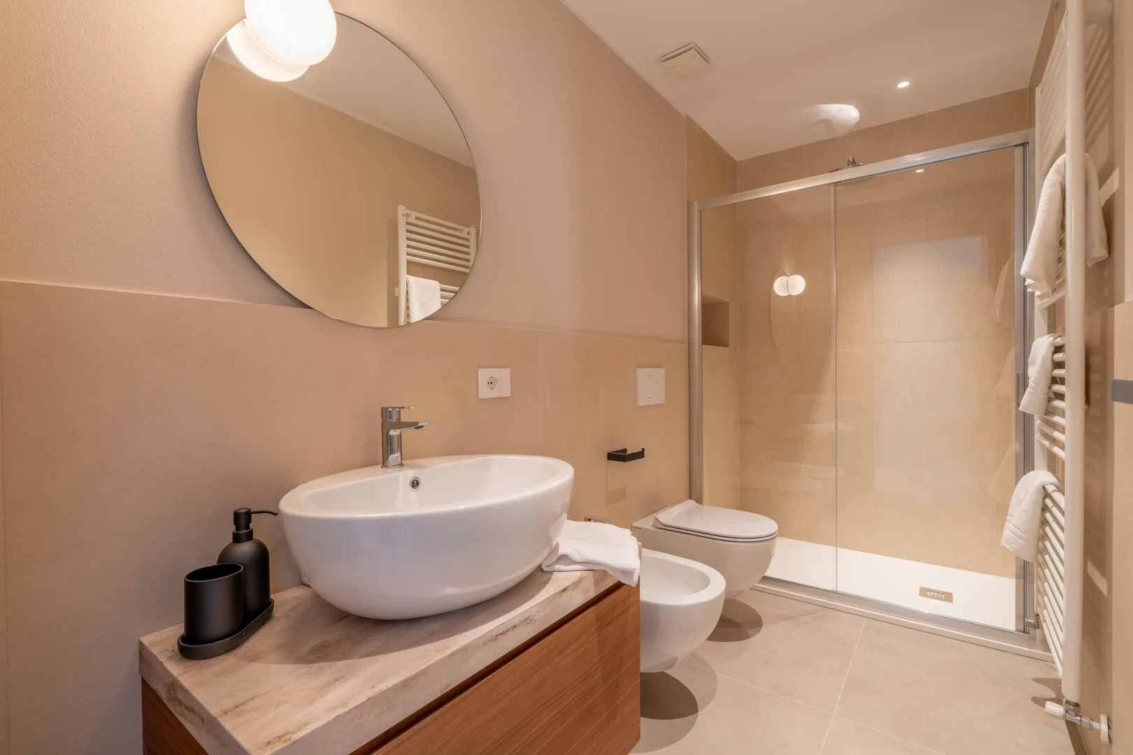 A bathroom with a basin, toilet, and glass shower area.
