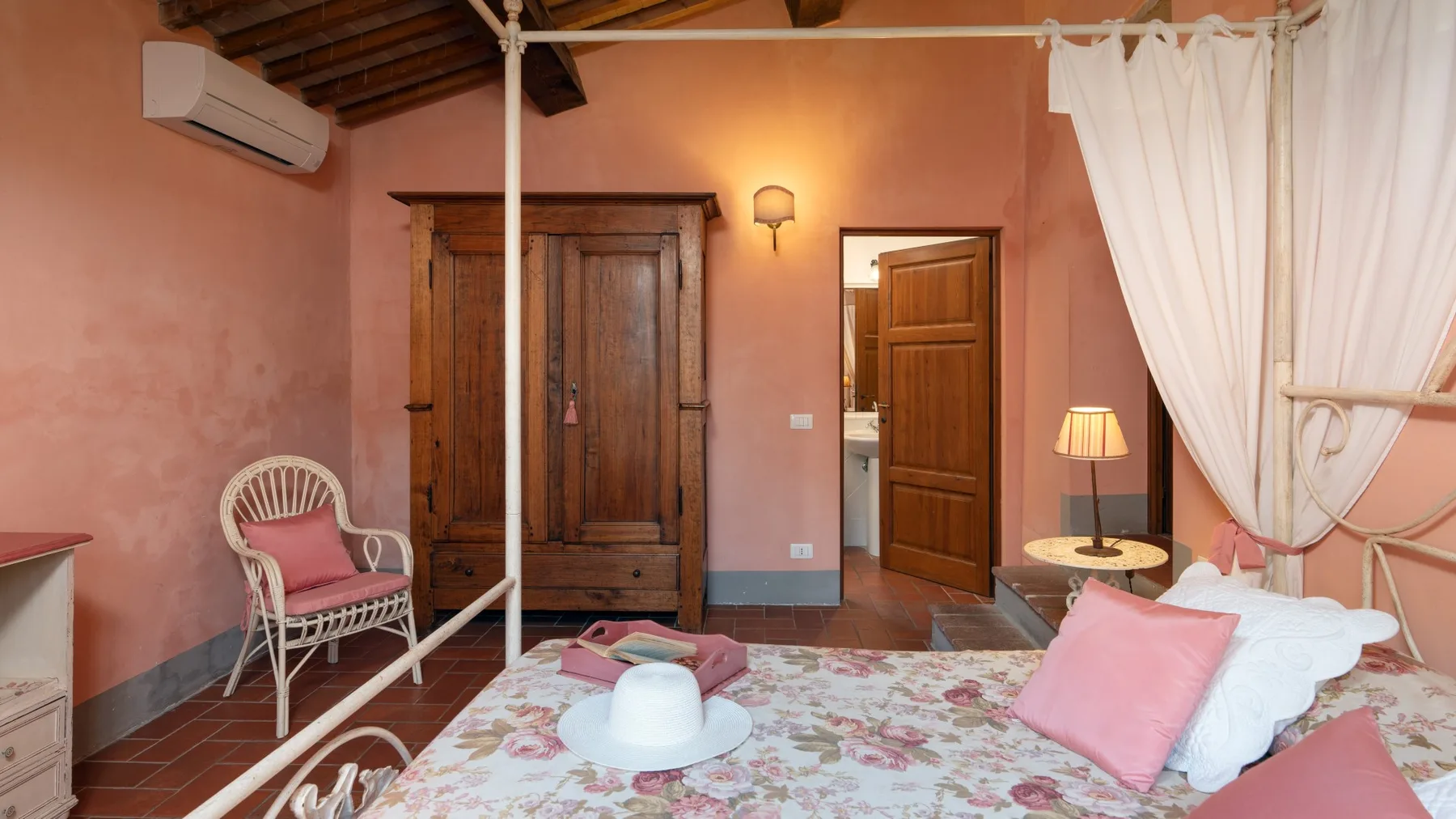 Un dormitorio con un armario de madera y una cama con ropa de cama floral.