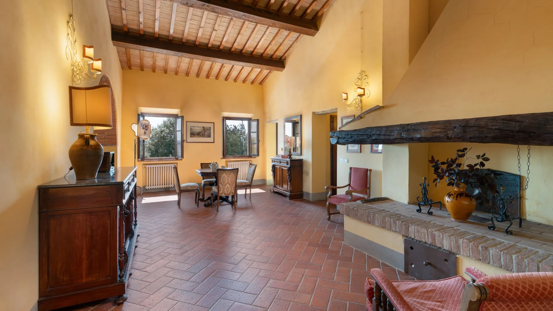 Una sala amplia con mesa de comedor y una gran chimenea.
