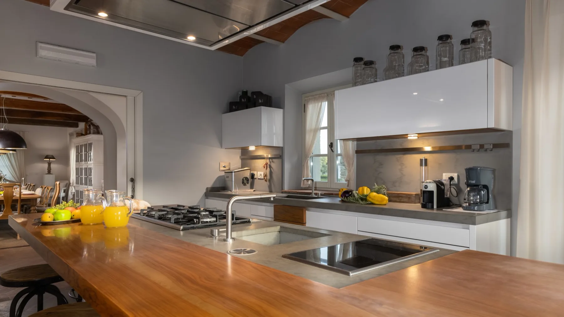 Una cocina moderna con una isla de madera, fregadero y zona de cocción.