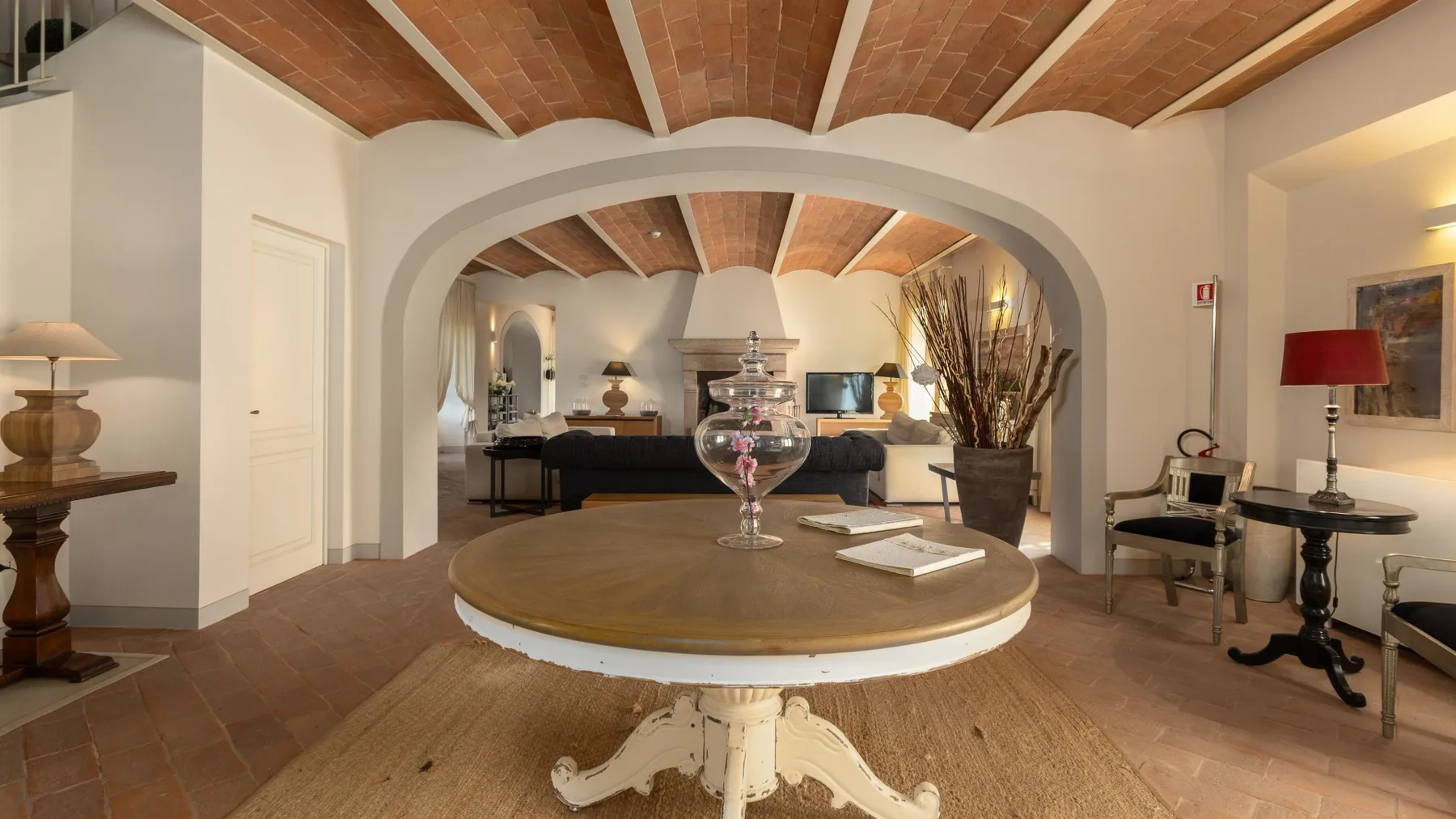 Una sala de estar con una zona de asientos redondeada y vigas de madera a la vista.