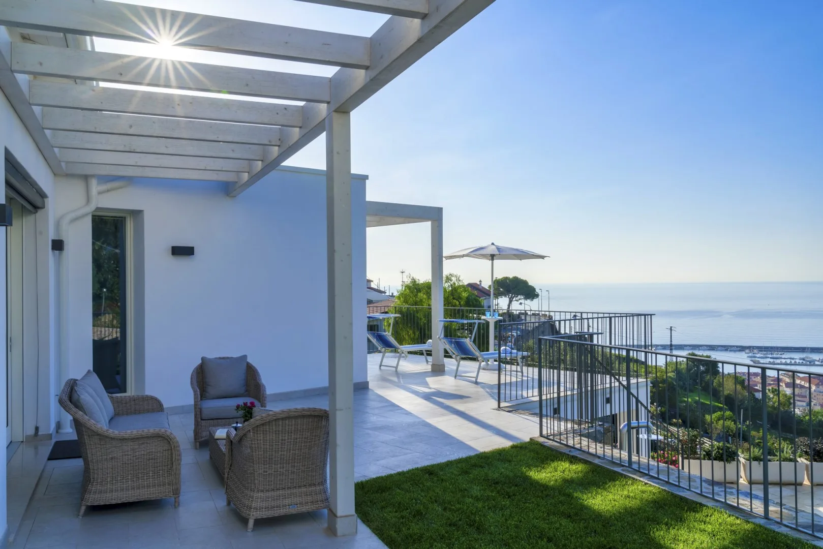 Un patio sombreado con asientos al aire libre da al mar.