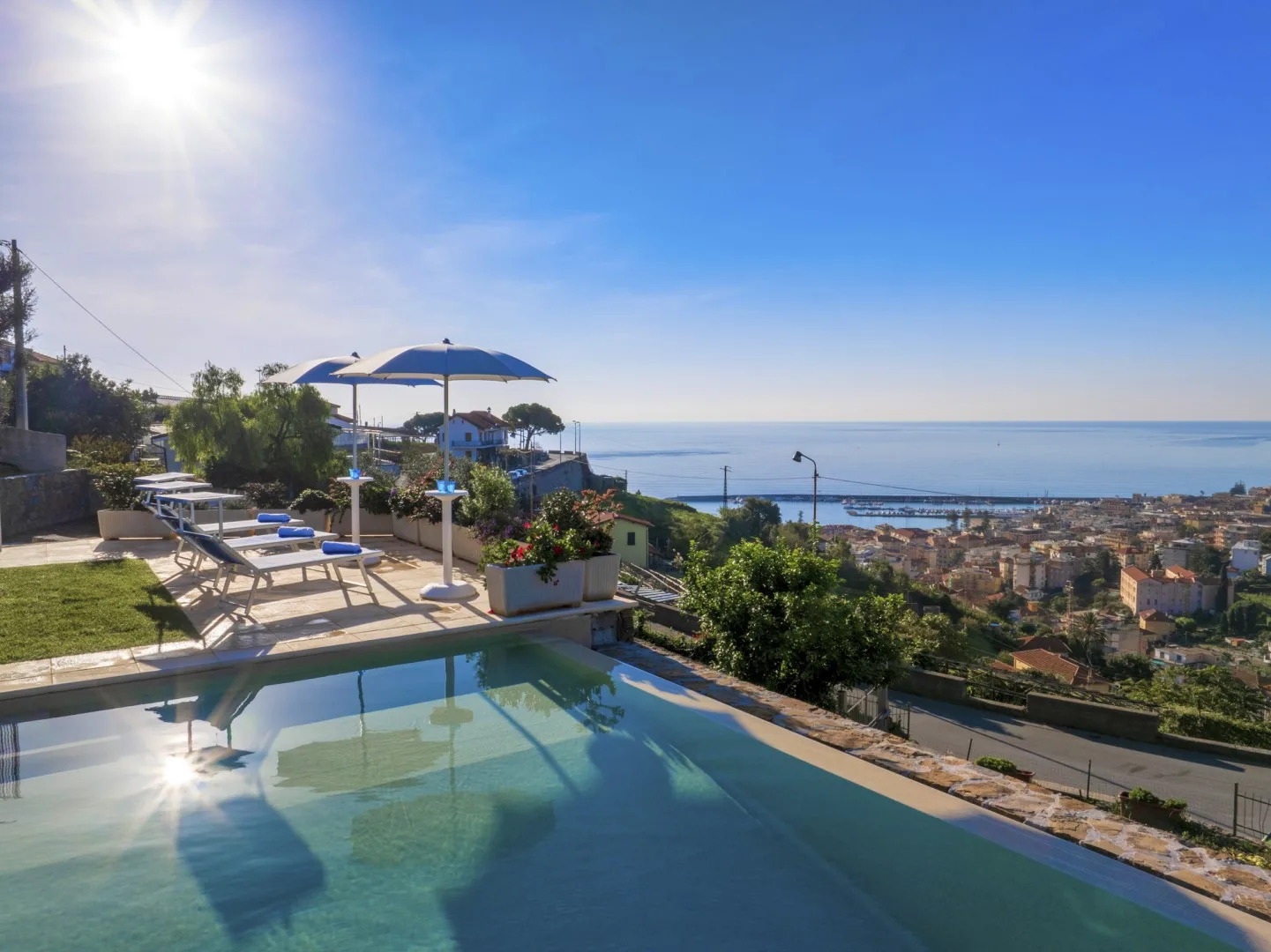 Una piscina al aire libre ofrece vistas de una ciudad costera y el mar.