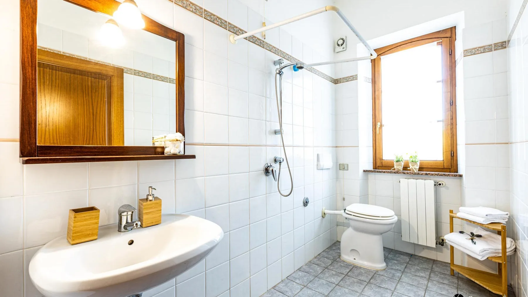 A tiled bathroom with a sink, shower, and toilet.