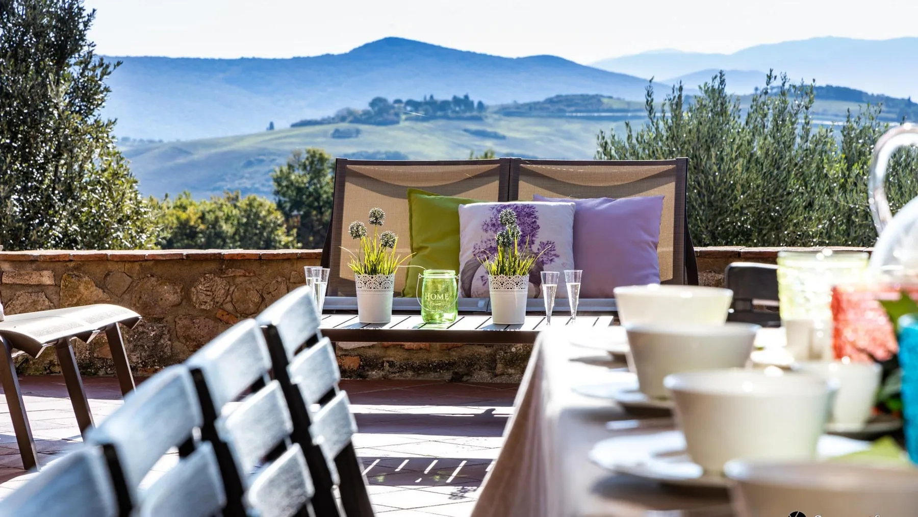 An outdoor dining terrace with a set table and mountain views.