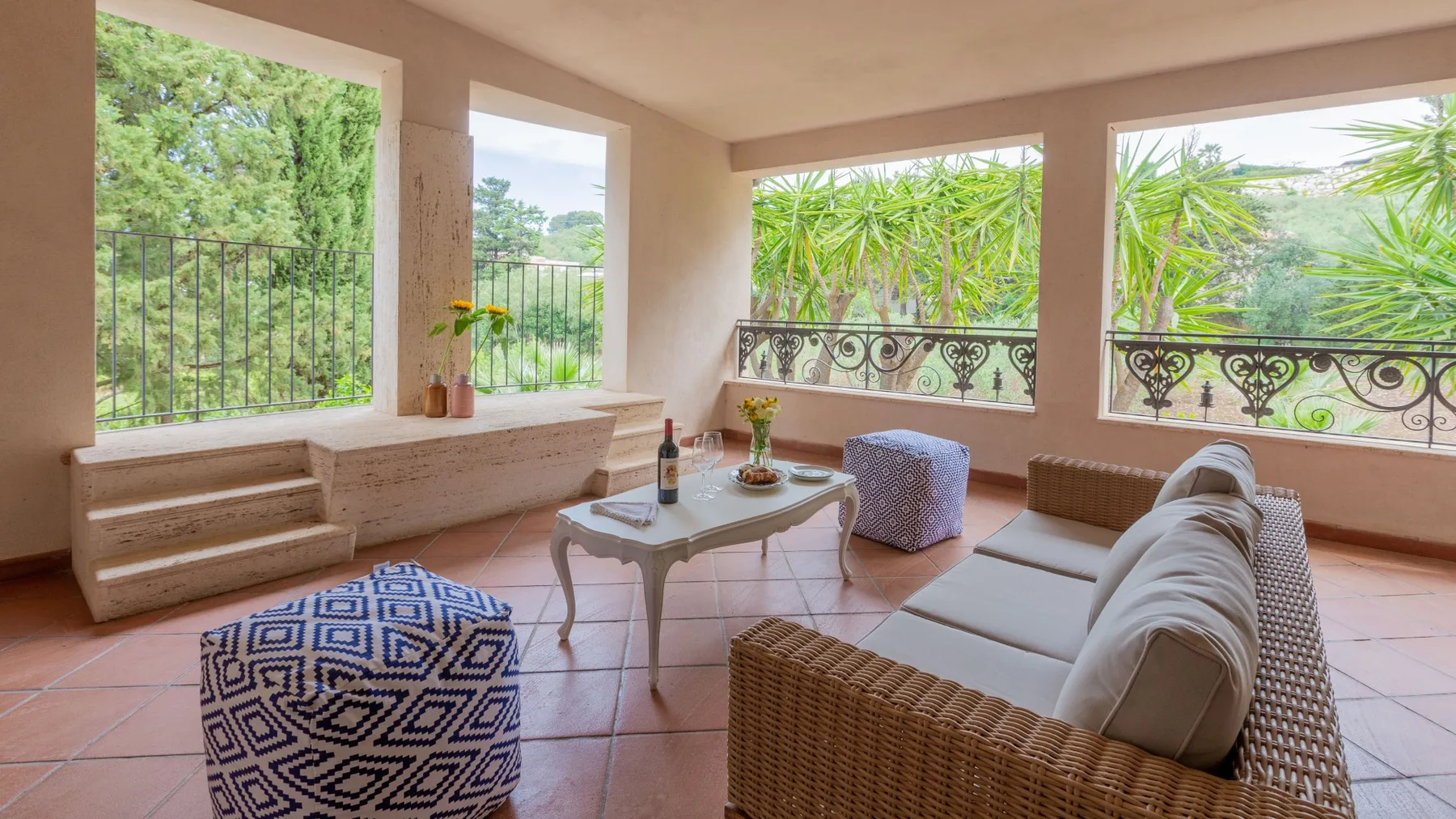Una sala cubierta con asientos acolchados y vistas abiertas a la vegetación.