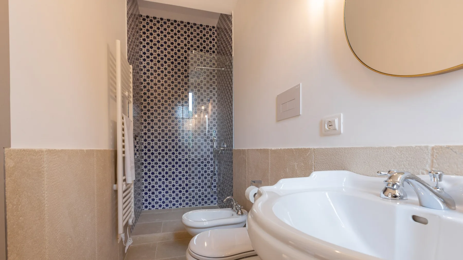 Un baño con bañera, lavabo y zona de ducha alicatada.