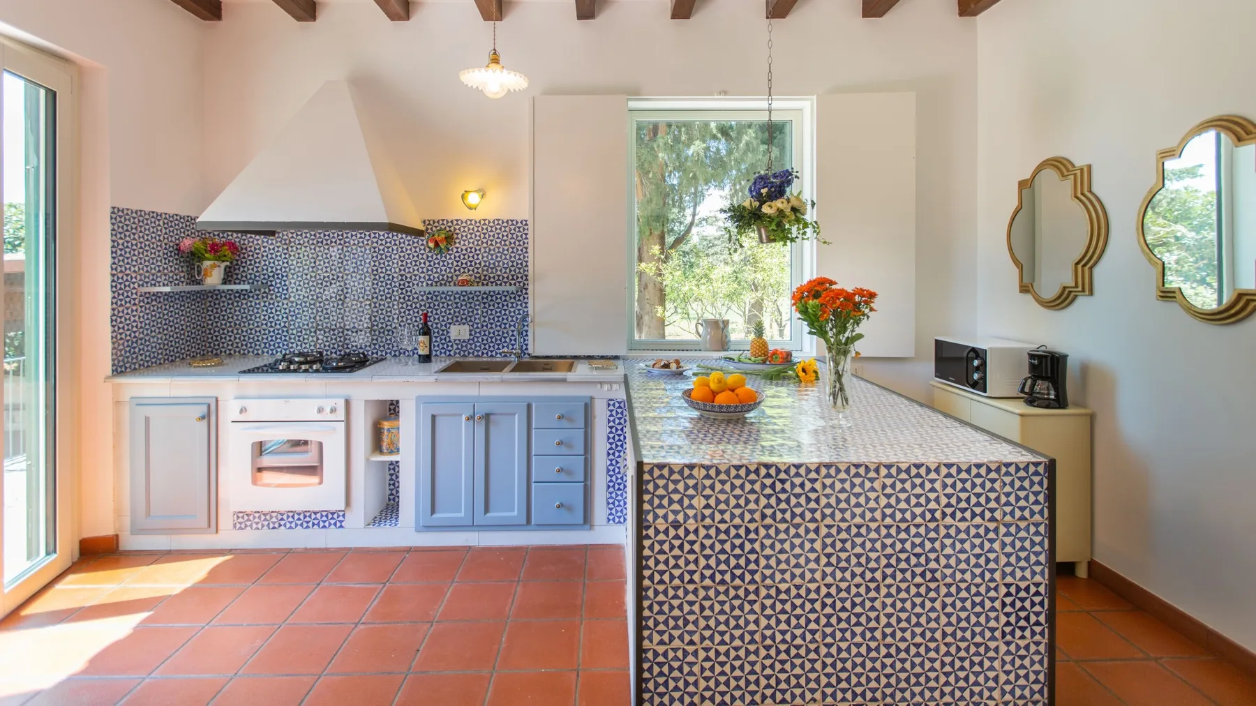 Una cocina luminosa con una isla estampada y suelo de baldosas.