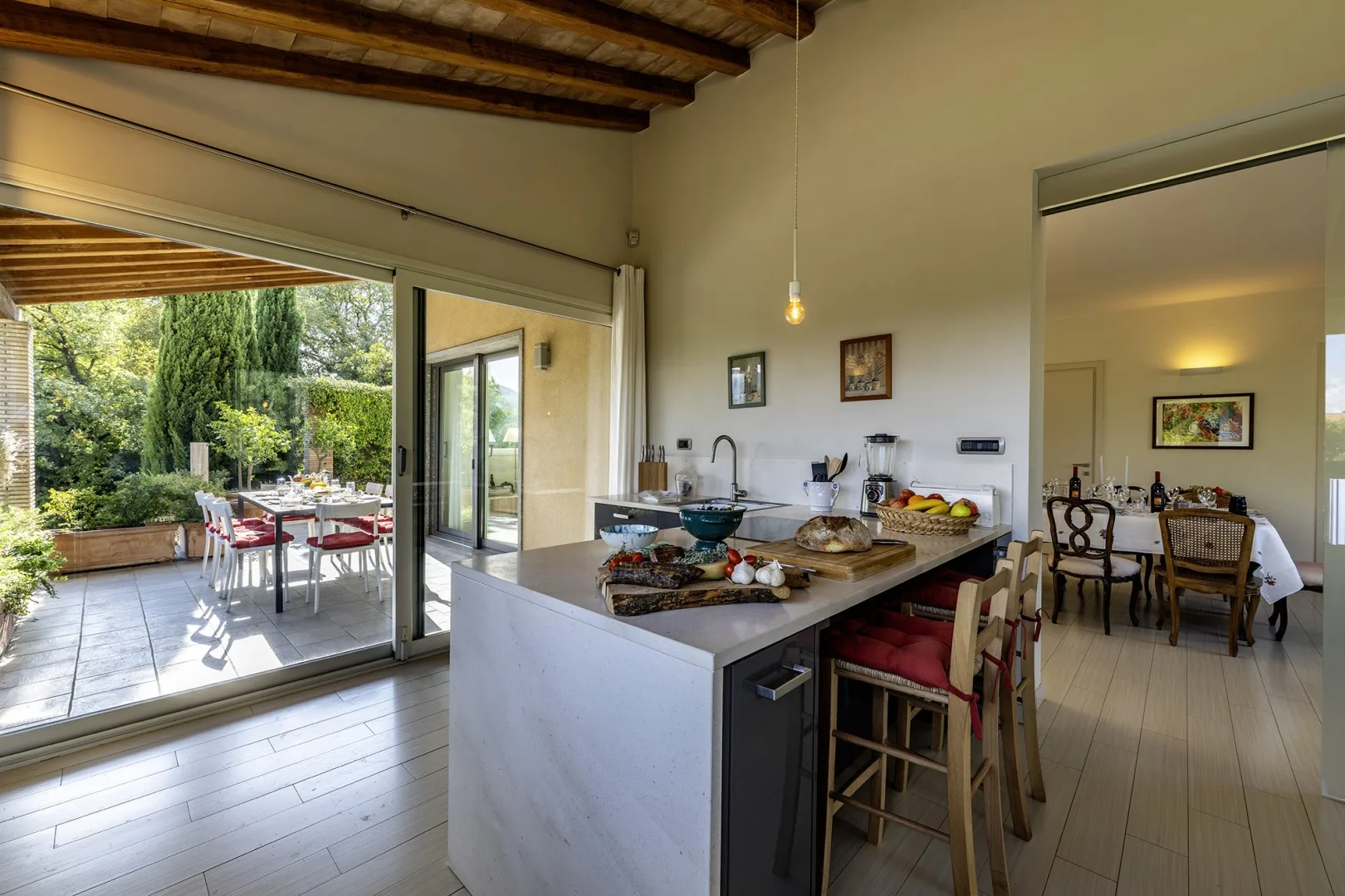 An open kitchen and dining area with an island beside sliding doors to a patio.
