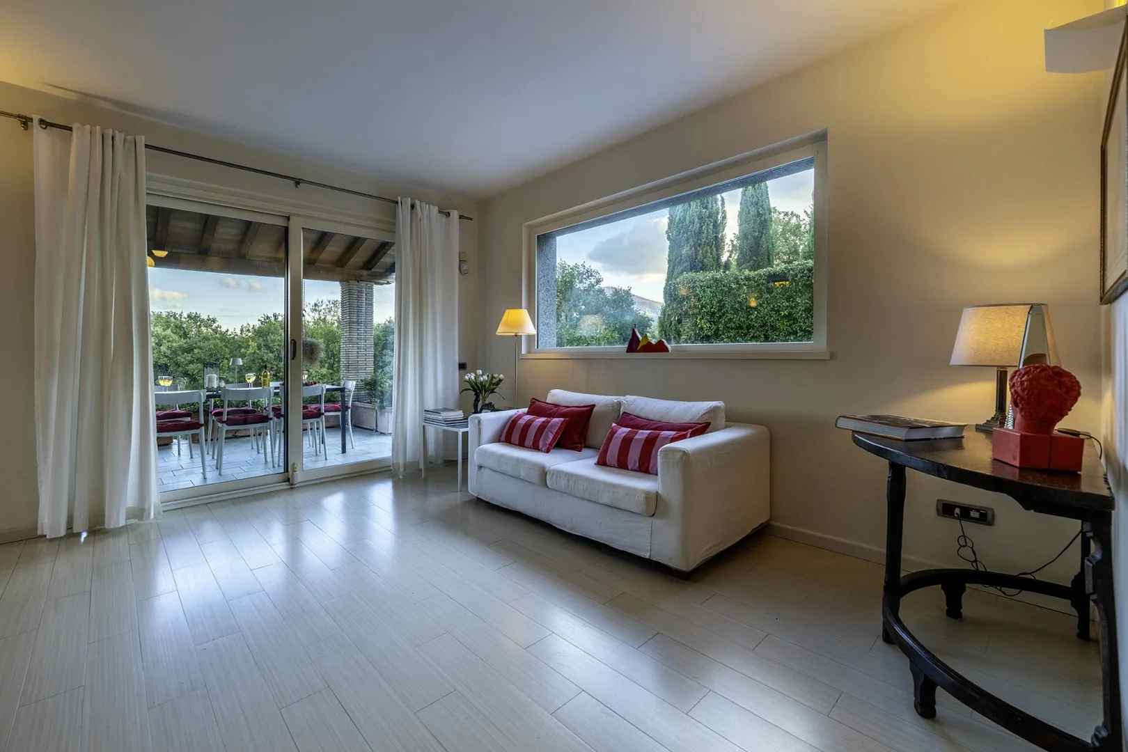 A bright living room with a white sofa beside a large window.