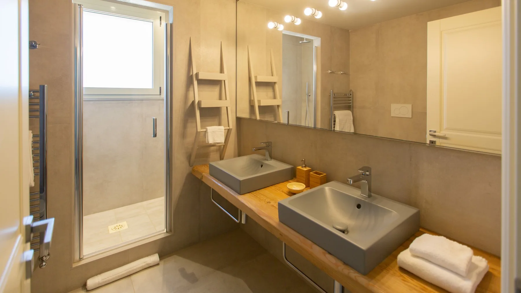 A bathroom with two sinks and a glass shower enclosure.