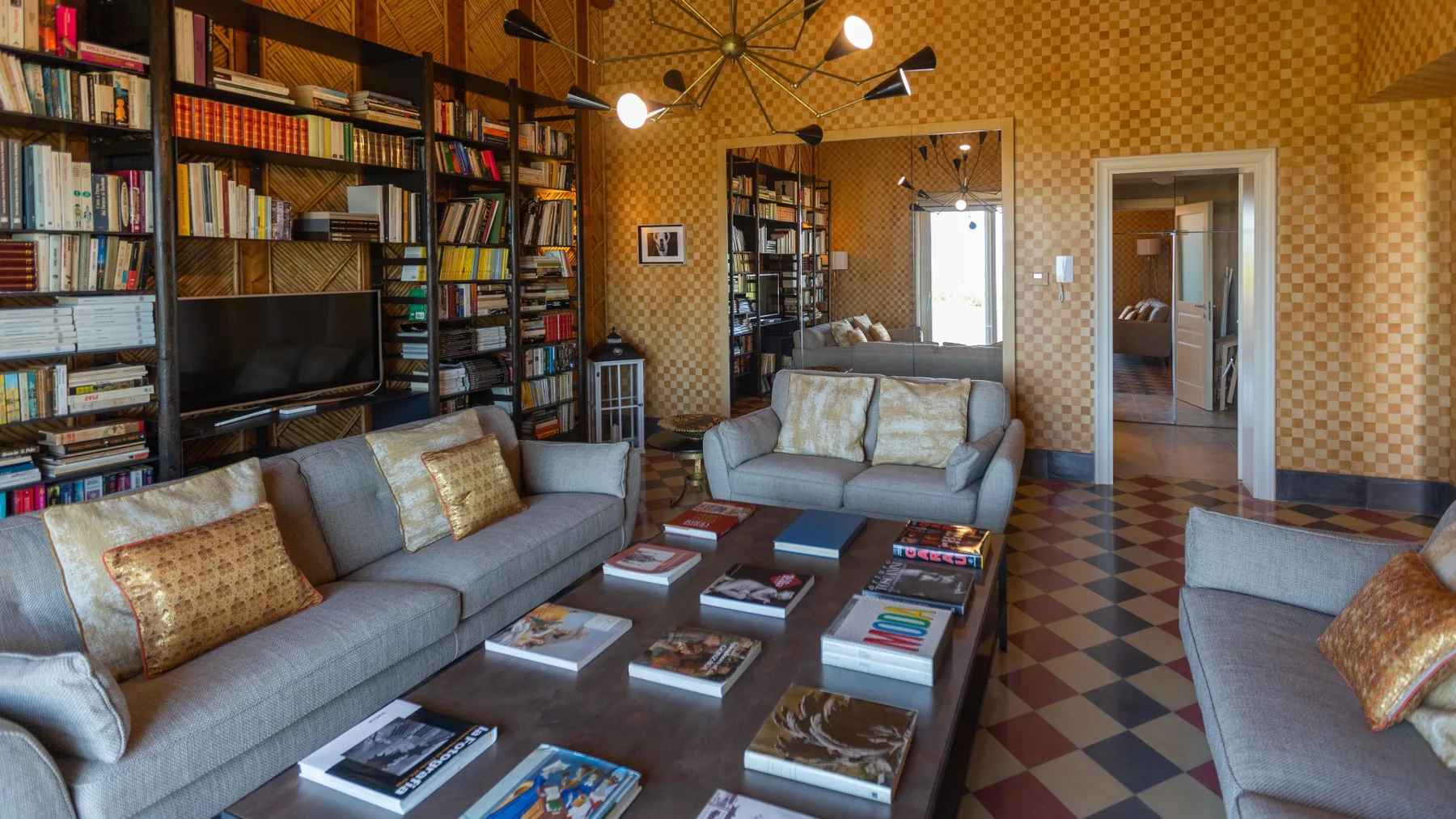 A living room with seating, bookshelves, and a television.