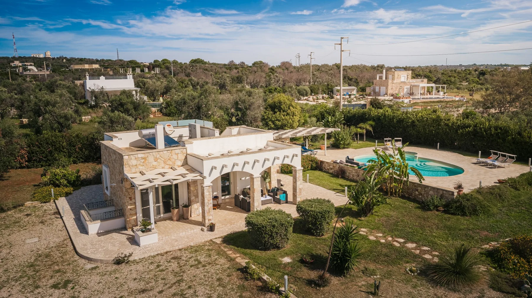 Una casa de una planta se encuentra junto a un jardín y una piscina.