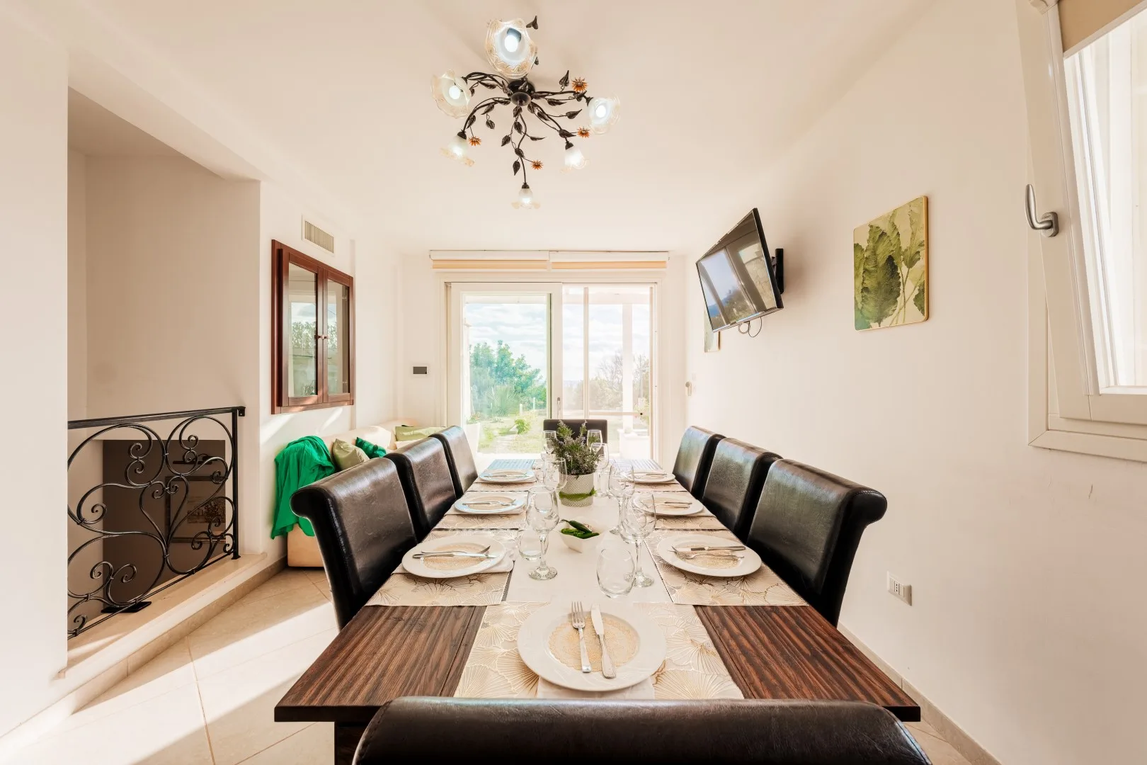Un comedor con una mesa larga puesta con platos y asientos.