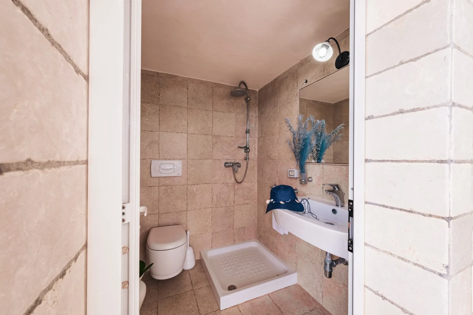 Un baño alicatado con ducha, inodoro y lavabo.