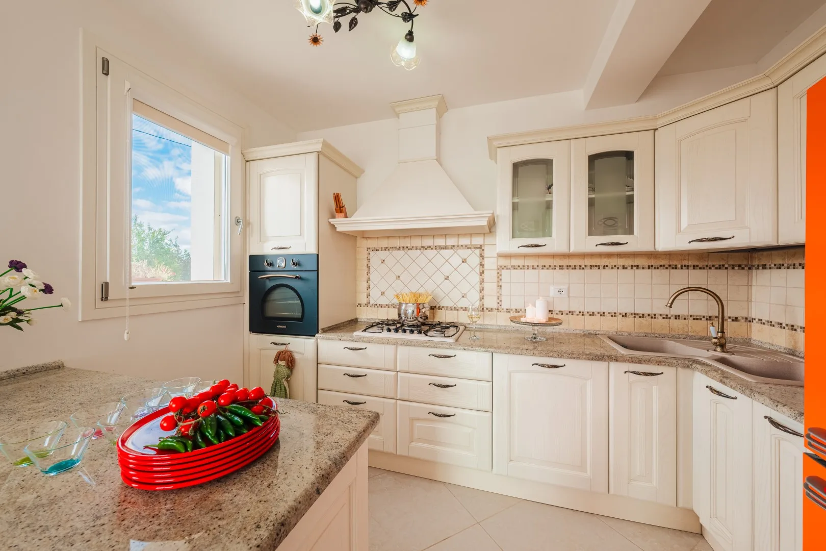 Una cocina luminosa con gabinetes blancos, una encimera y una ventana.