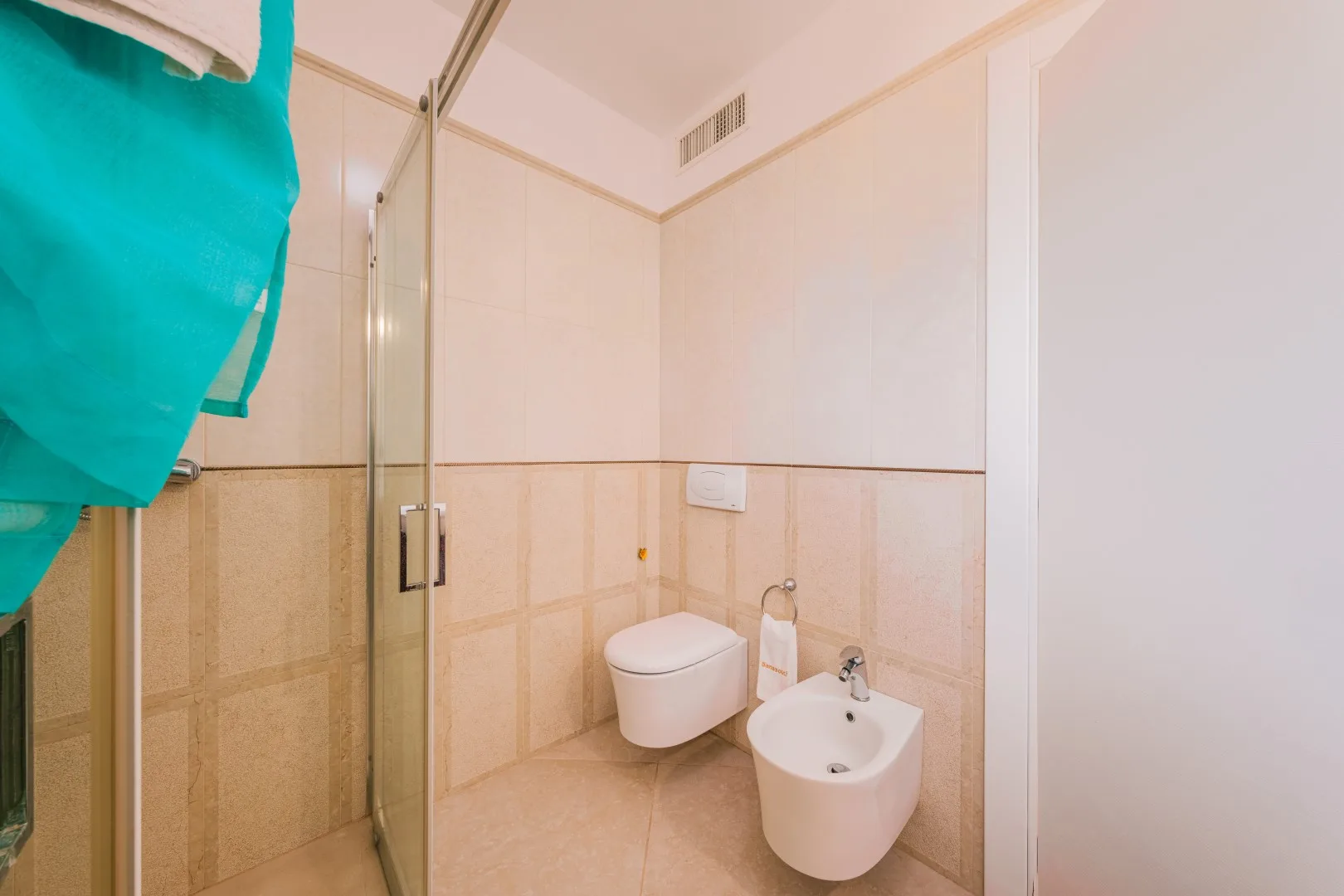 Un baño con una mampara de ducha de vidrio, inodoro y bidé.