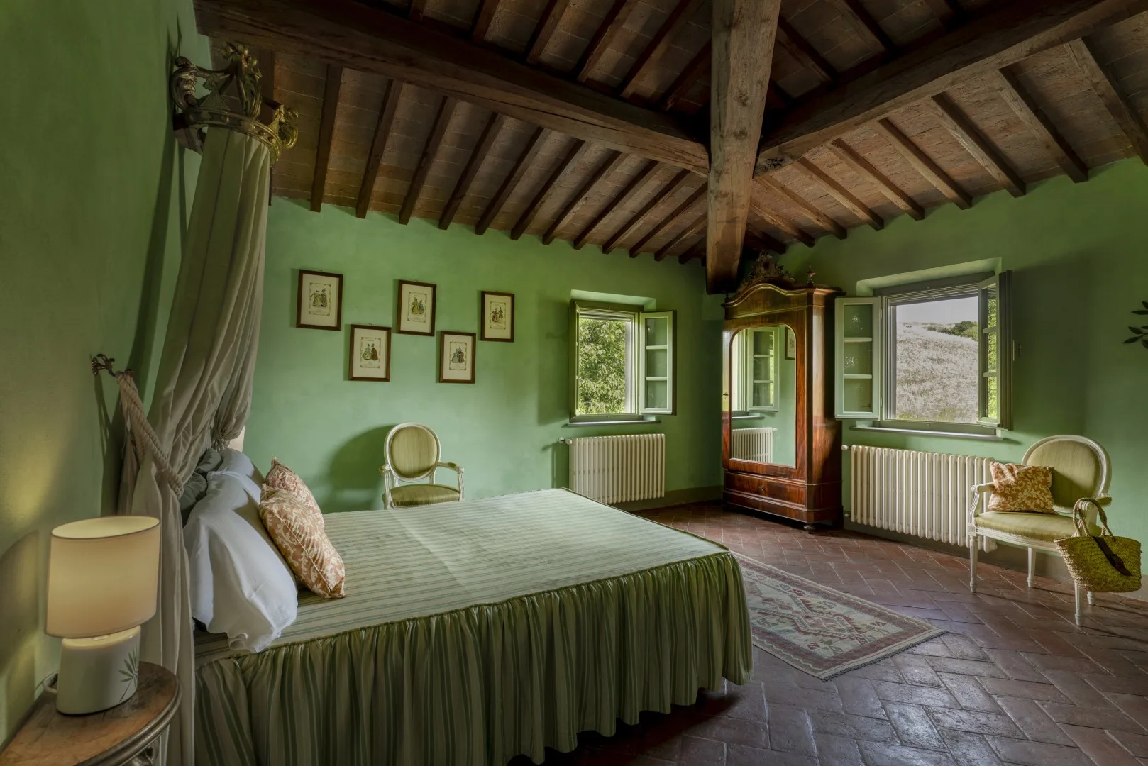Dormitorio con una cama grande, paredes verdes y ventanas bajo un techo de madera.