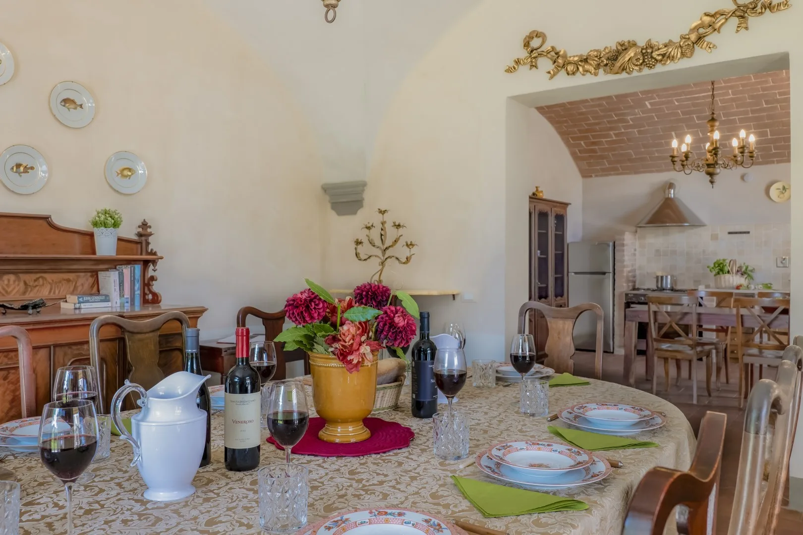 Comedor con una mesa puesta y una cocina abierta al fondo.