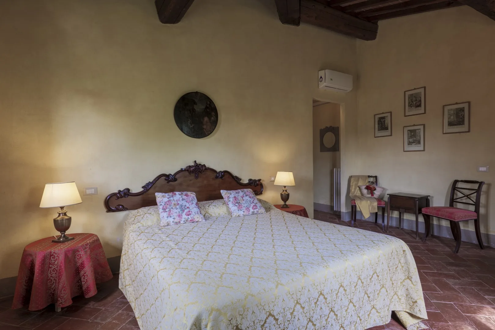 Un dormitorio con una cama grande, mesas de noche y cuadros en la pared.