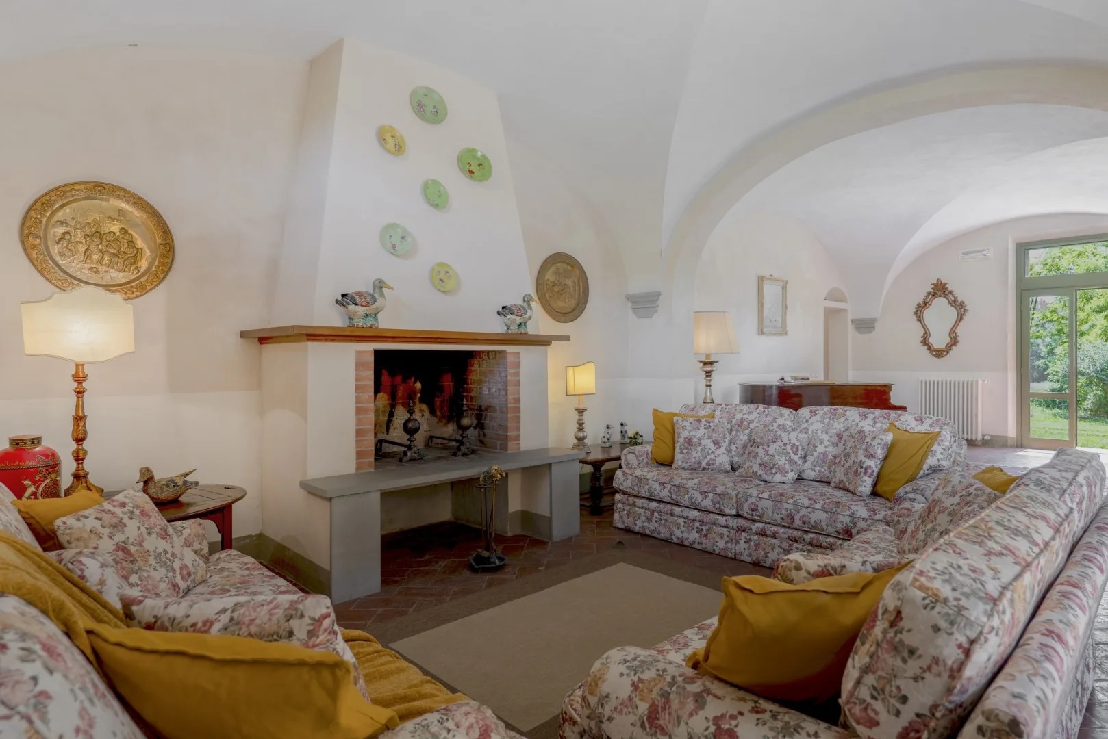 Una sala de estar con asientos florales dispuestos alrededor de una chimenea.