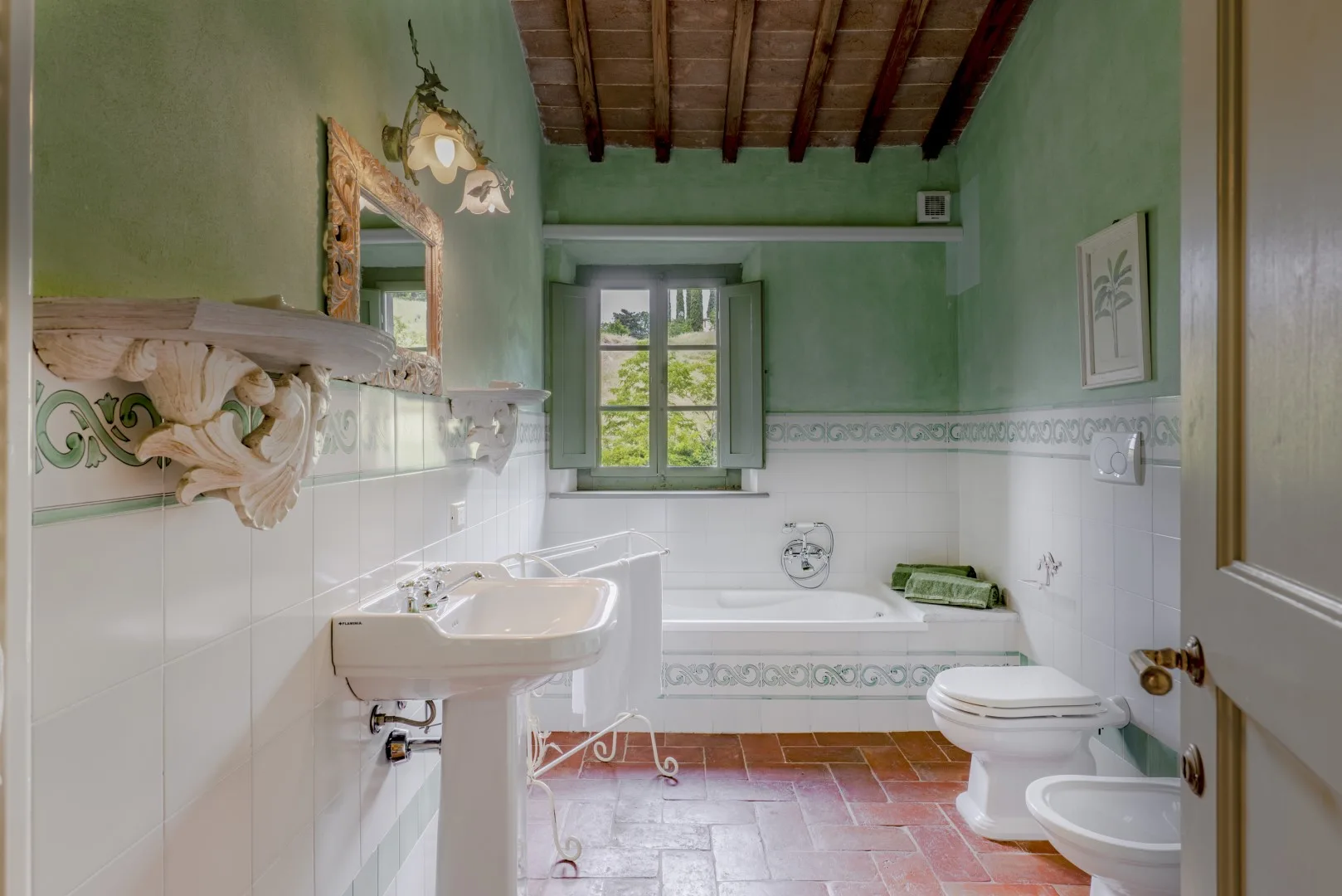 Un baño con bañera, lavabo y ventana.