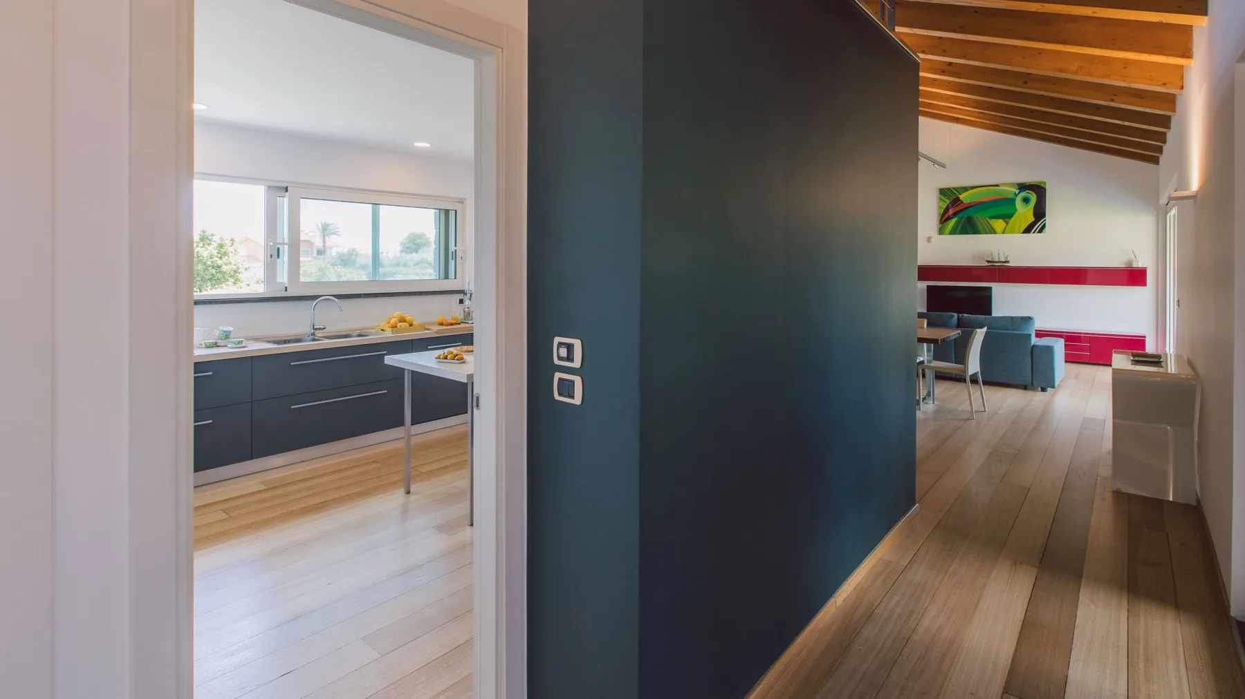Un pasillo interior moderno comunica con una cocina y un comedor.