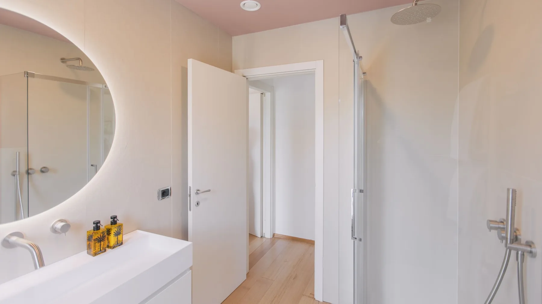 Un baño con un espejo grande, un lavabo y una ducha de vidrio.