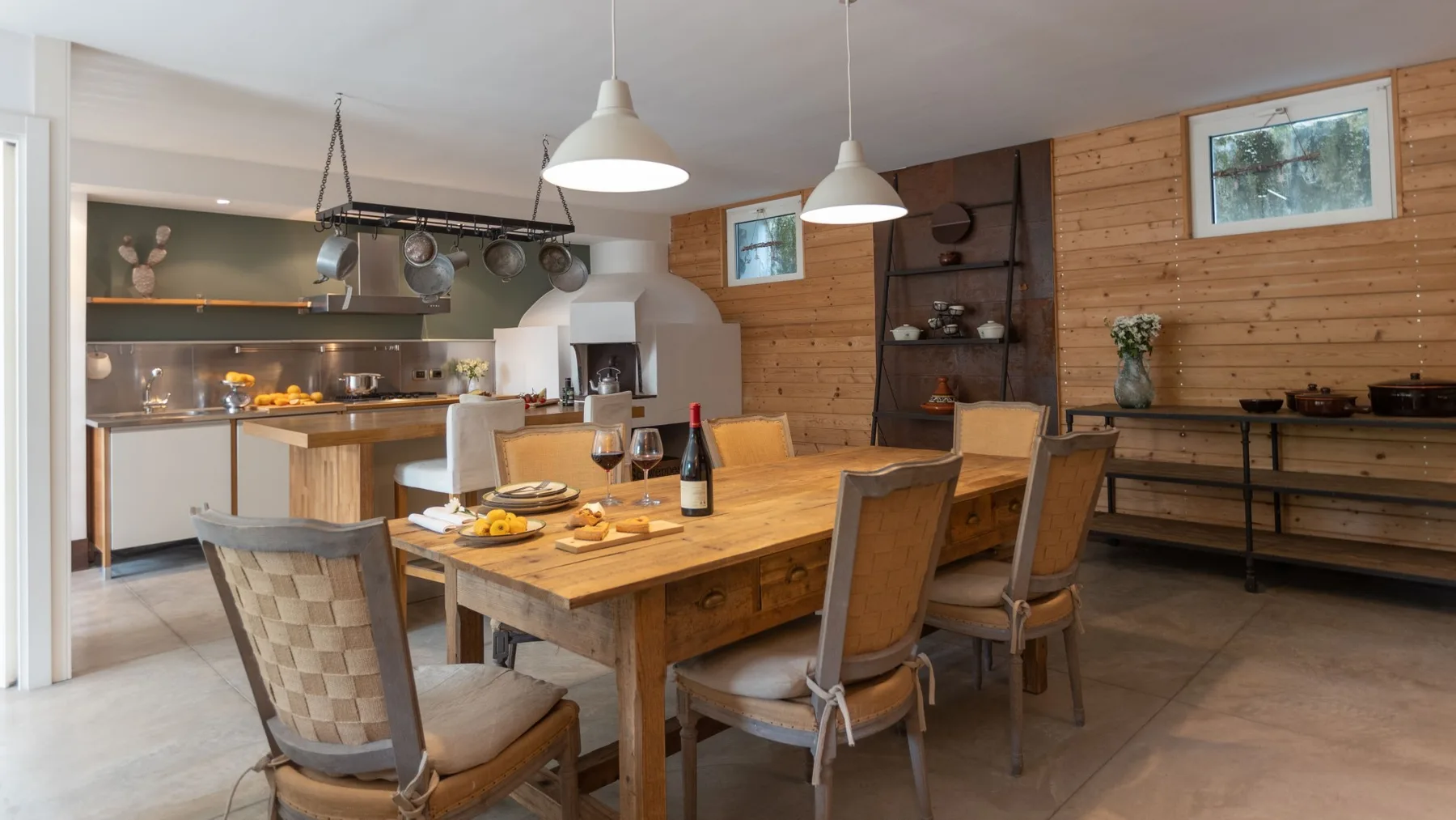 Comedor con una mesa de madera y sillas junto a una cocina abierta.