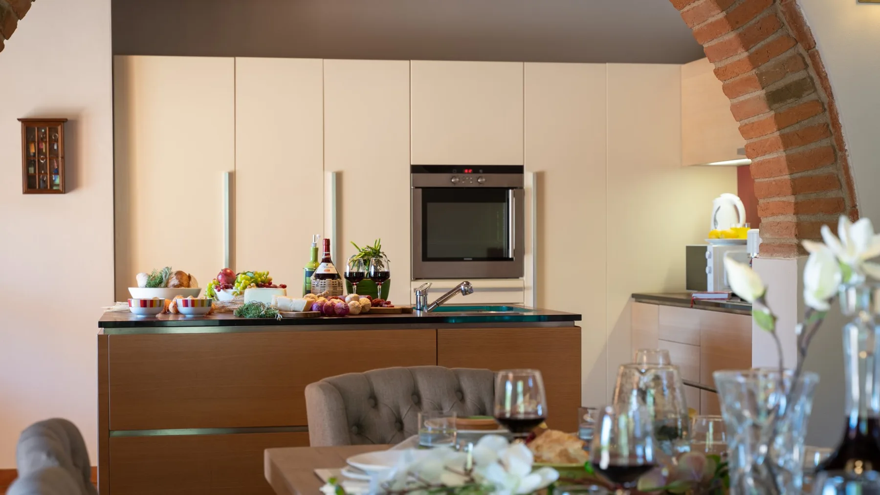 Un comedor con la mesa puesta da a una cocina con electrodomésticos empotrados.