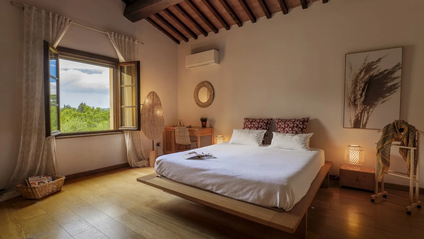 Un dormitorio con una cama elevada, una ventana abierta y vigas de madera a la vista.